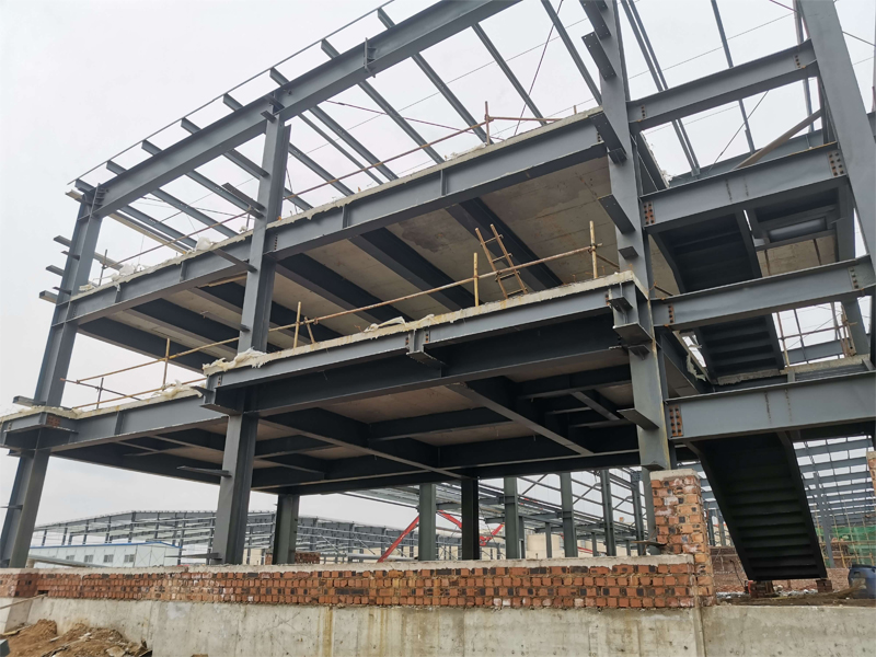 Estrutura metálica de galpão em construção, com vigas, pilares e mezanino — referência