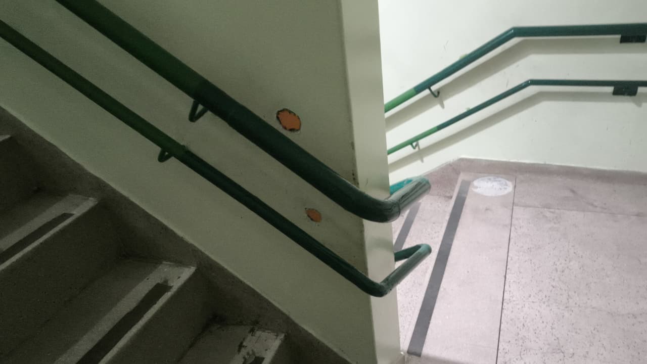 Corrimãos metálicos verdes instalados em escada pela Titanium