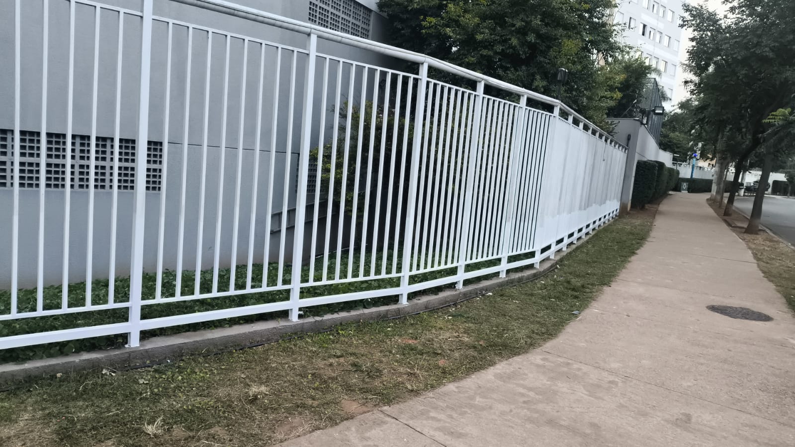 Gradil metálico branco instalado pela Titanium no perímetro de um condomínio