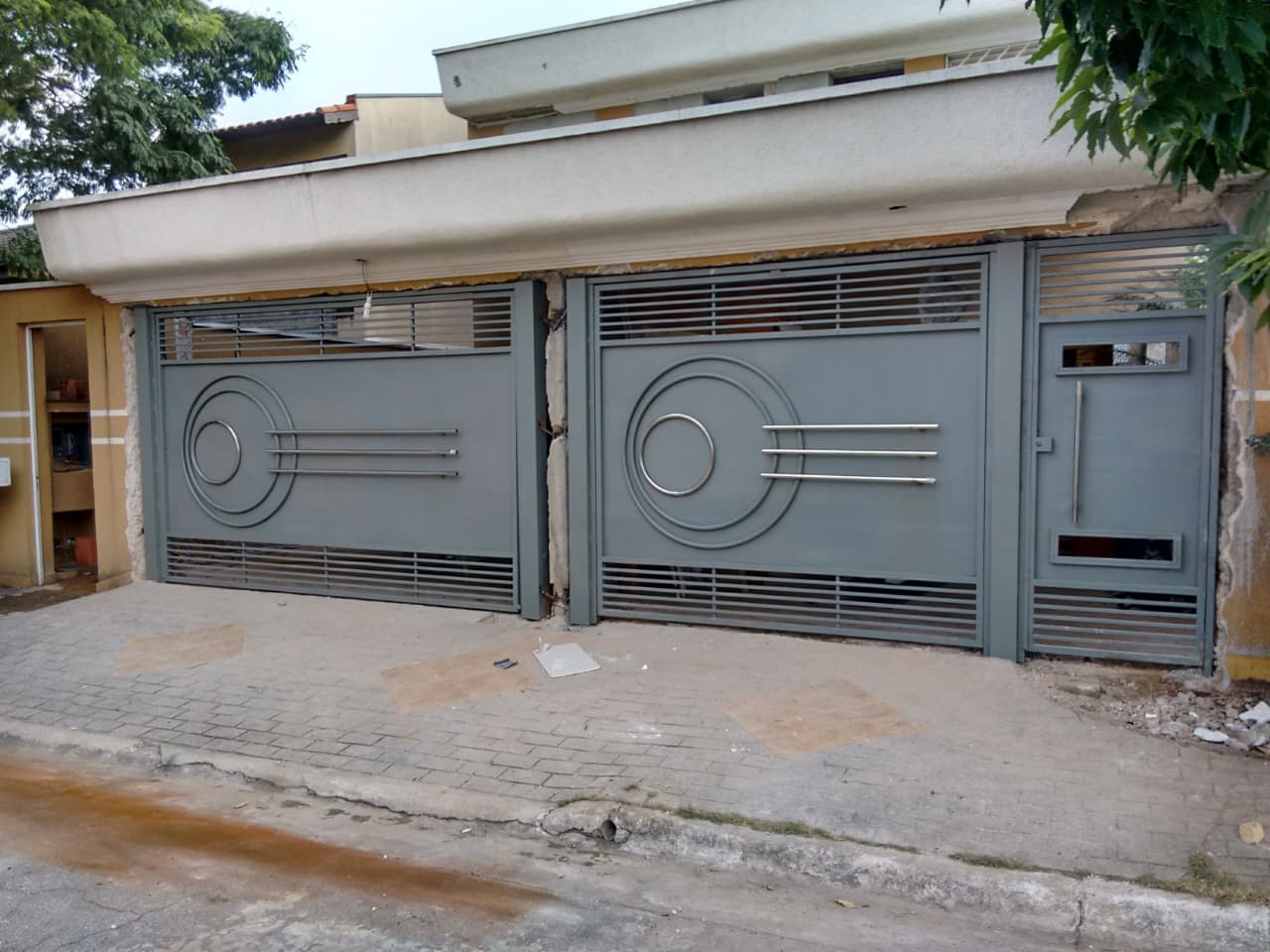 Conjunto de portões metálicos cinza fabricado e instalado pela Titanium